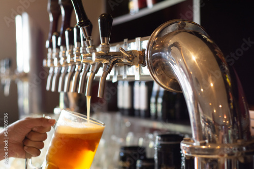Fotografía canillas de cerveza artesanal sirviendo un vaso con espuma