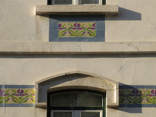 Streets of Lisbon. Detail of traditional Revival facade decorated by tiles with lily flowers. Portugal. 