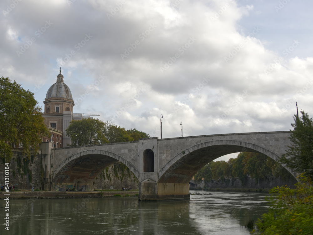 The Saint Angelo bridge spanning the Tiber river in Rome Italy as seen on a fall day.
