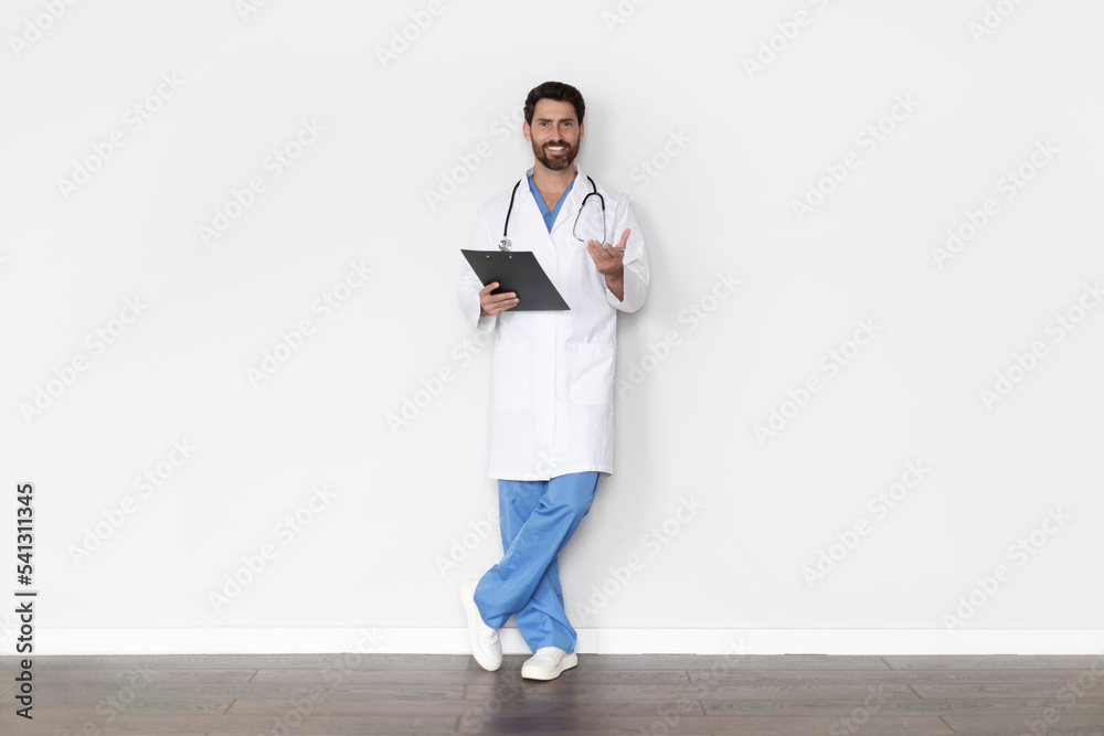 Portrait Of Handsome Male Doctor In Uniform With Clipboard In Hands Portrait Of Handsome Male Doctor In Uniform With Clipboard In Hands