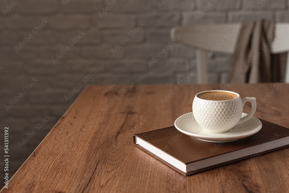 The concept of wishing a productive day. A cup of fragrant cappuccino on a wooden kitchen table. Still life in the style of minimalism. Horizontal photo. Selective focus. Place for text. The concept of wishing a productive day. A cup of fragrant cappuccino on a wooden kitchen table. Still life in the style of minimalism. Horizontal photo. Selective focus. Place for text.