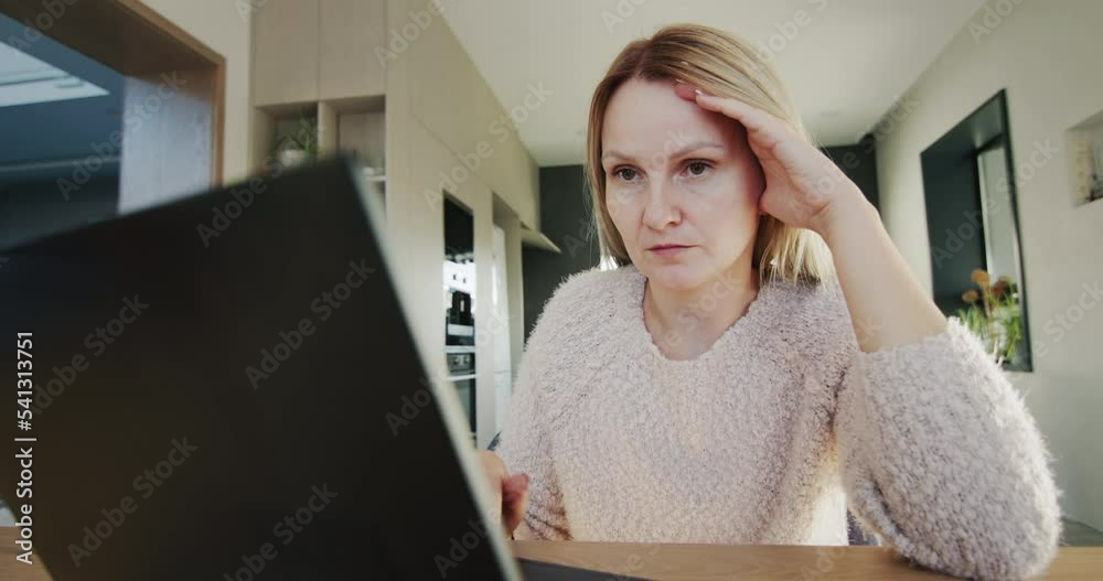 Thoughtful sad woman sitting at laptop monitor. Wide lens 4k shot