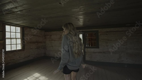 Tracking shot of teenage girl exploring abandoned house in ghost town / Grafton, Utah, United States photo