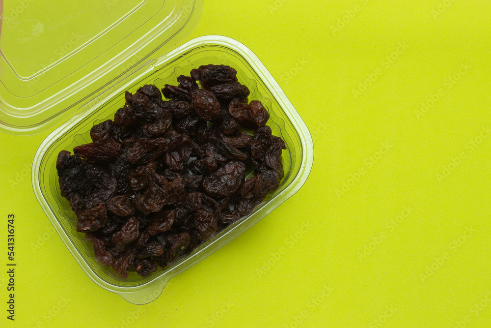 bowl full of raisins on a colored background bowl full of raisins on a colored background