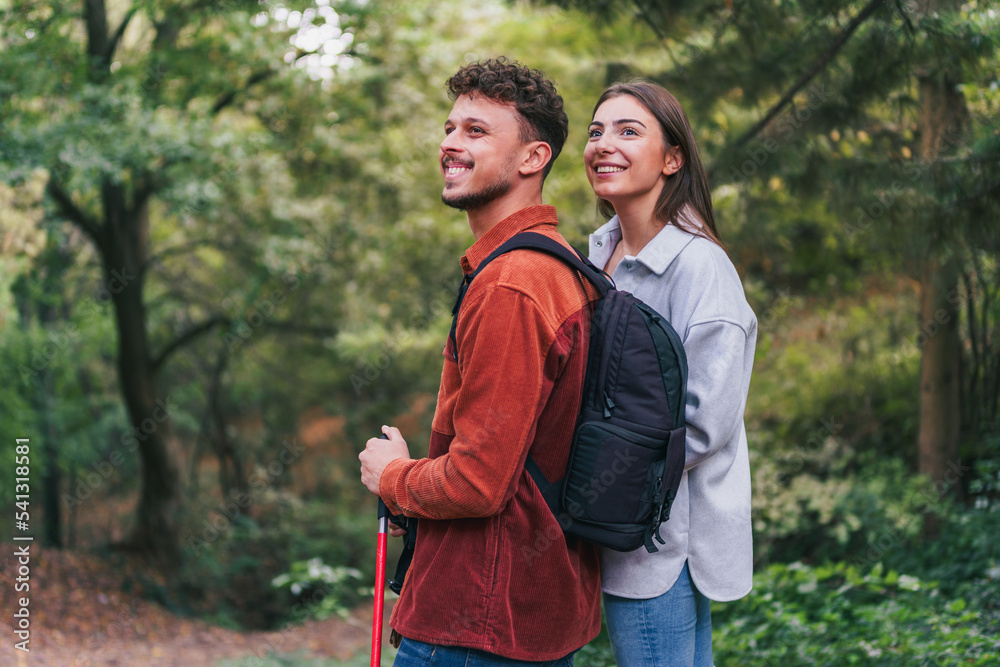 A happy couple stopped during their hike to absorb wonderful nature and breathtaking greenery. They appear to be enjoying their adventure. A happy couple stopped during their hike to absorb wonderful nature and breathtaking greenery. They appear to be enjoying their adventure.