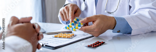 doctor or pharmacist advises patients about pills. The doctor prescribes medication sitting at a table in the clinic office. to find the best course of treatment. follow-up treatment