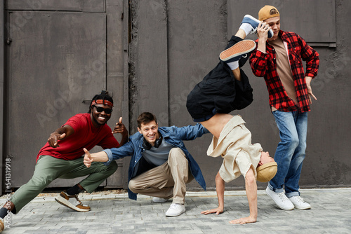 Full length shot of all male hip-hop team posing outdoors and looking at camera