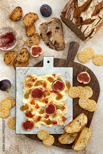 Butter board topped with fresh figs, fig jam, spicy paprika jelly and chili threads. Trend food photo
