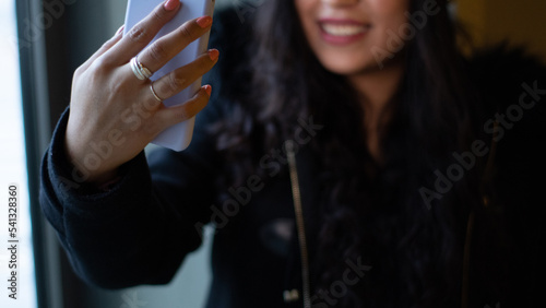face of a pretty Latina girl who is shopping in a mall, taking a smiling selfie and wearing a hair band.