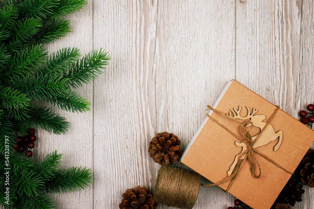 Fir branches and cones. Christmas background with decorations, reindeer and gift boxe on wooden board. Top view. Fir branches and cones. Christmas background with decorations, reindeer and gift boxe on wooden board. Top view.