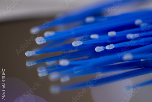 Set of blue microbrushes for eyelashes on a mirror background with bokeh