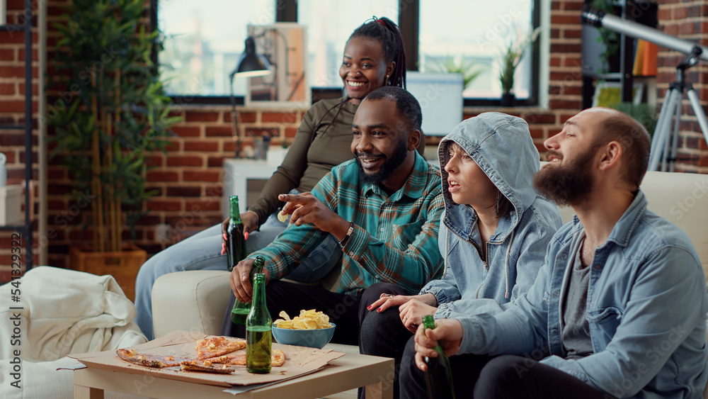 Cheerful people watching film on television and drinking beer, having fun together at weekend hangout. Friend being happy and enjoying comedy movie on tv channel program, leisure activity. Cheerful people watching film on television and drinking beer, having fun together at weekend hangout. Friend being happy and enjoying comedy movie on tv channel program, leisure activity.