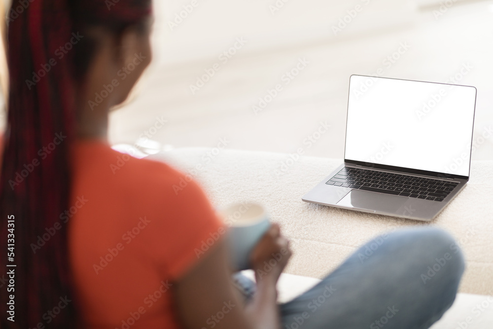 Black Woman Using Laptop With White Screen And Drinking Coffee At Home Black Woman Using Laptop With White Screen And Drinking Coffee At Home