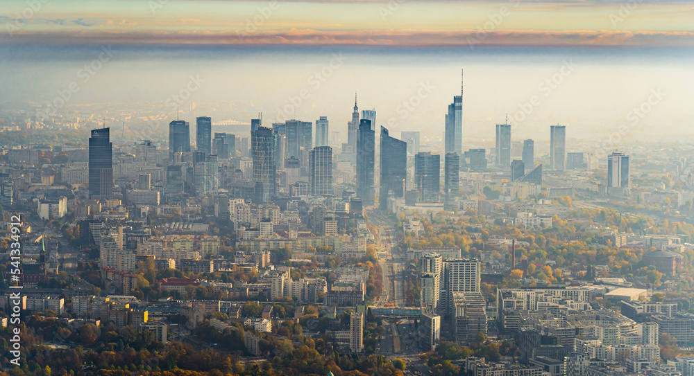 Stunning aerial view of downtown Warsaw from plane window. Autumn morning. Sunrise with fog over the city. Modern skyscrapers. High quality photo