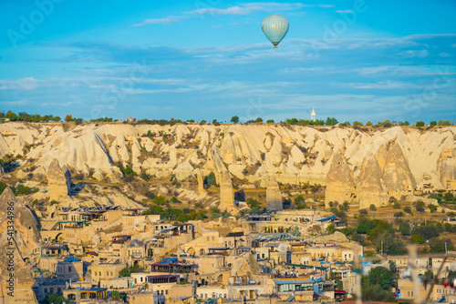 Stunning panoramic shot of Turkish town of Cappadocia know for its amazing rock formations with ancient caves and organizing hot air balloon trips over the city. Vivid blue sky. Unconventional city