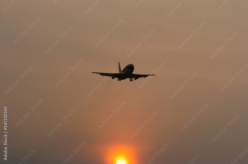 Silhouette image of a passenger plane about to land at the airport, at sunset. Safe felling when the weather is sunny Silhouette image of a passenger plane about to land at the airport, at sunset. Safe felling when the weather is sunny