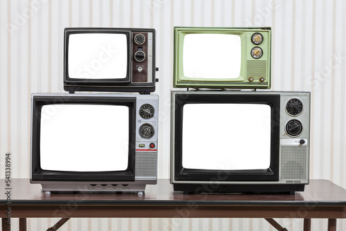 Four vintage televisions on table with cut out screens.