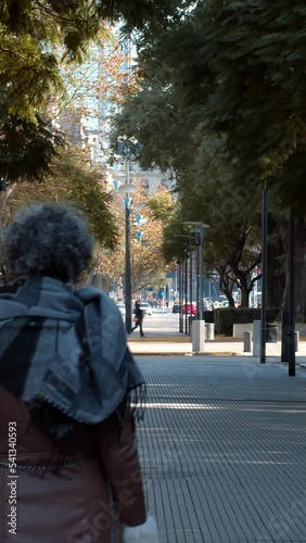 Mujer caminando por un camino de arboles	