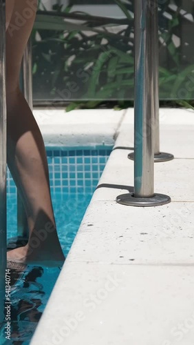 woman legs walking towards pool a sunny day	