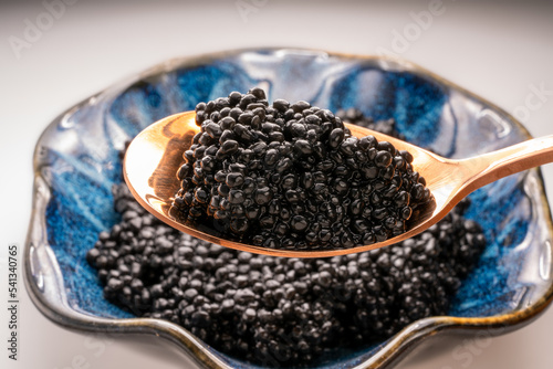 Luxury Black caviar in golden spoon, Texture of expensive luxury caviar. Food concept.