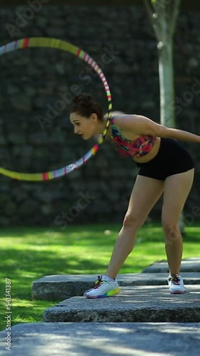 mujer jugando con un aro en un parque	
