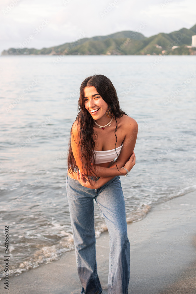 Young woman smiling on the beach. Hispanic lifestyle concept. Young woman smiling on the beach. Hispanic lifestyle concept.