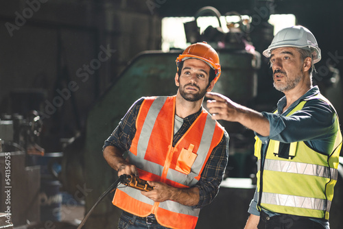 professional technician engineer working to check safety system of heavy industry manufacturing machine in construction plant and service a factory equipment of production job technology