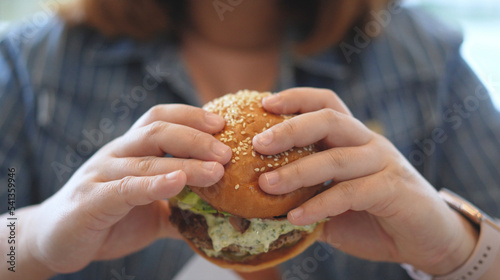 Woman enjoy eating a hamburger 