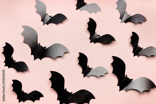 Fototapeta Naklejka Na Ścianę i Meble -  Minimal flat lay with black bats as halloween party background. Pattern from paper decorations flying bats on beige pink background for holiday card or invitation. Aesthetic halloween concept
