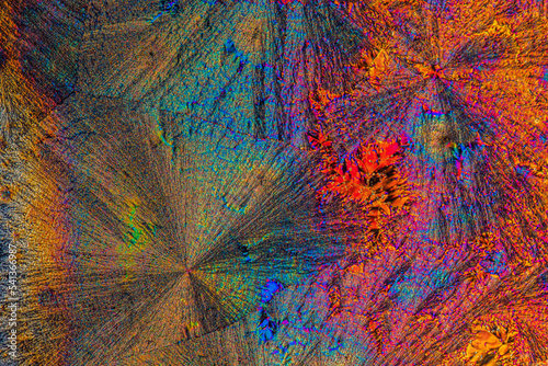 Extreme macro photograph of Vitamin C crystals forming abstract modern art patterns, when illuminated with polarized light, under a microscope objective with 10x magnification