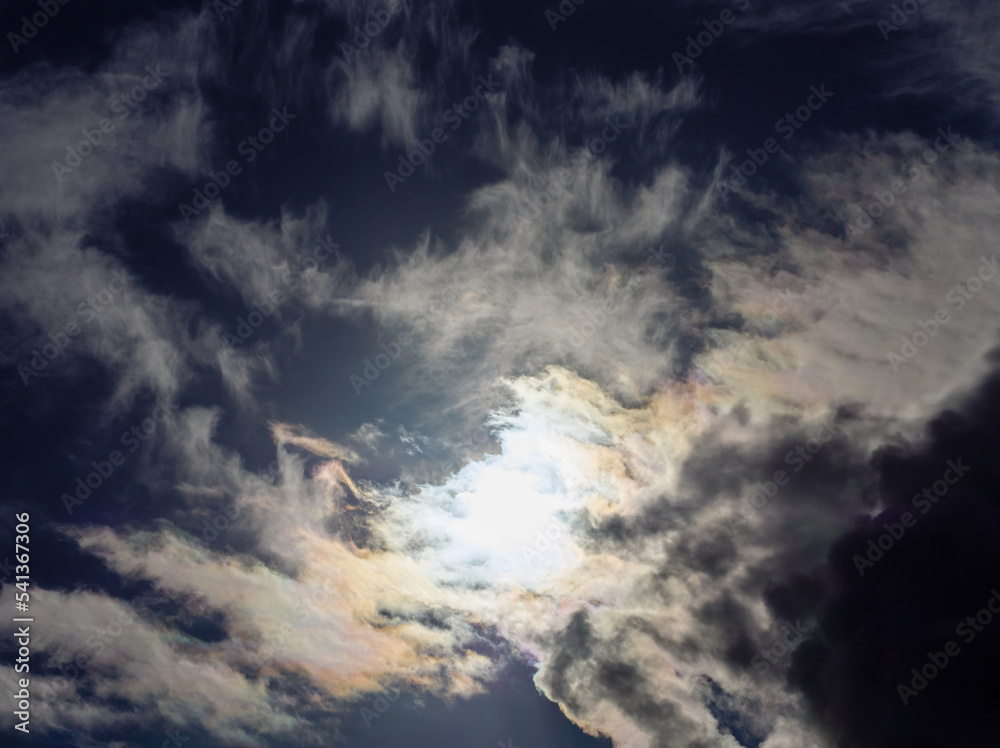 The sun shines into overcast dark yellow-blue clouds The sun shines into overcast dark yellow-blue clouds