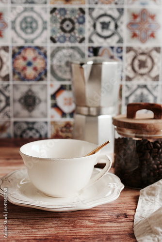 Fototapeta Naklejka Na Ścianę i Meble -  Coffee cup mockup and kitchen utensils table Portuguese and Spain Azulejo tile background,trendy Eco style home still life. Space for text or menu . Business food brand template. 