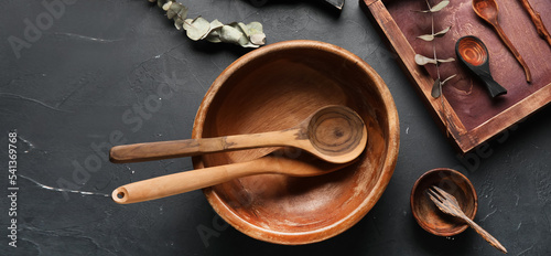 Wooden cooking utensils on dark background photo