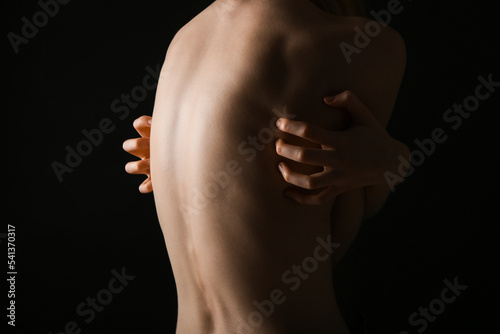 Tela Back of young woman on dark background. Anorexia concept