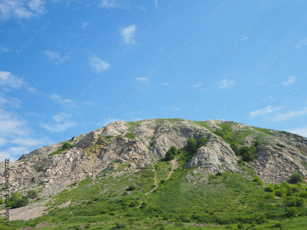 Mountain closeup and blue sky with white clouds. Beautiful summer landscape.