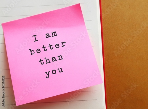 Pink note on envelope background with handwritten text SUPERIORITY COMPLEX, means belief that your abilities or accomplishments are dramatically better than someone else