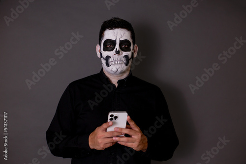 Fotografie hombre maquillado de catrin o calavera para el dia de muertos como tradición mex