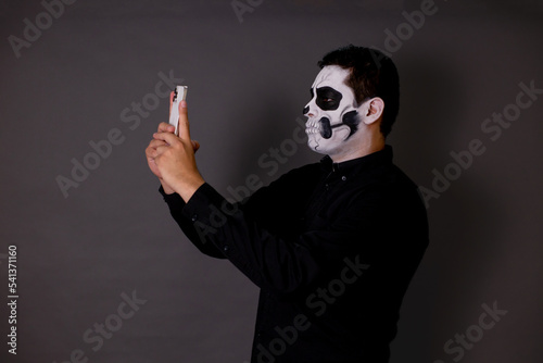 hombre maquillado de catrin o calavera para el dia de muertos como tradición mexicana con cara pintada con el concepto tradicional mexicano photo