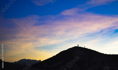 Silhouettes of people in mountain sunset