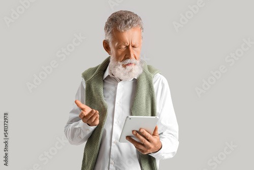 Thoughtful mature man using...
