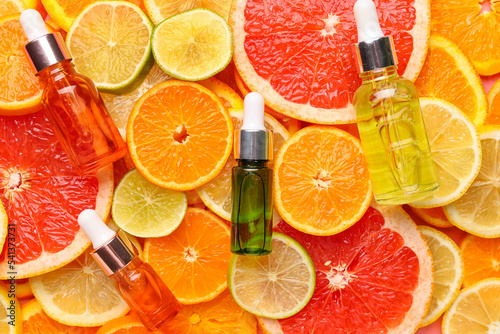 Fototapeta Naklejka Na Ścianę i Meble -  Bottles with vitamin C serum on slices of citrus fruits