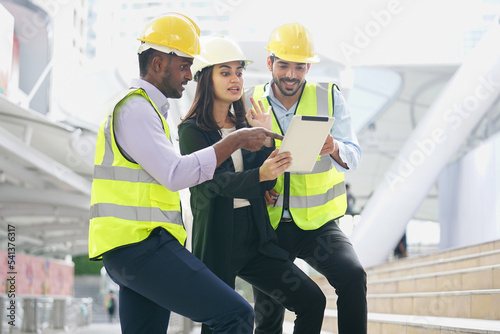 multiracial business engineers or architects team talking discussing online by tablet outside building, engineering teamwork working outdoor on site