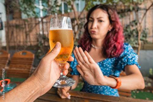 Obraz na plátně Funny drunk woman refuses an extra glass of beer at the bar