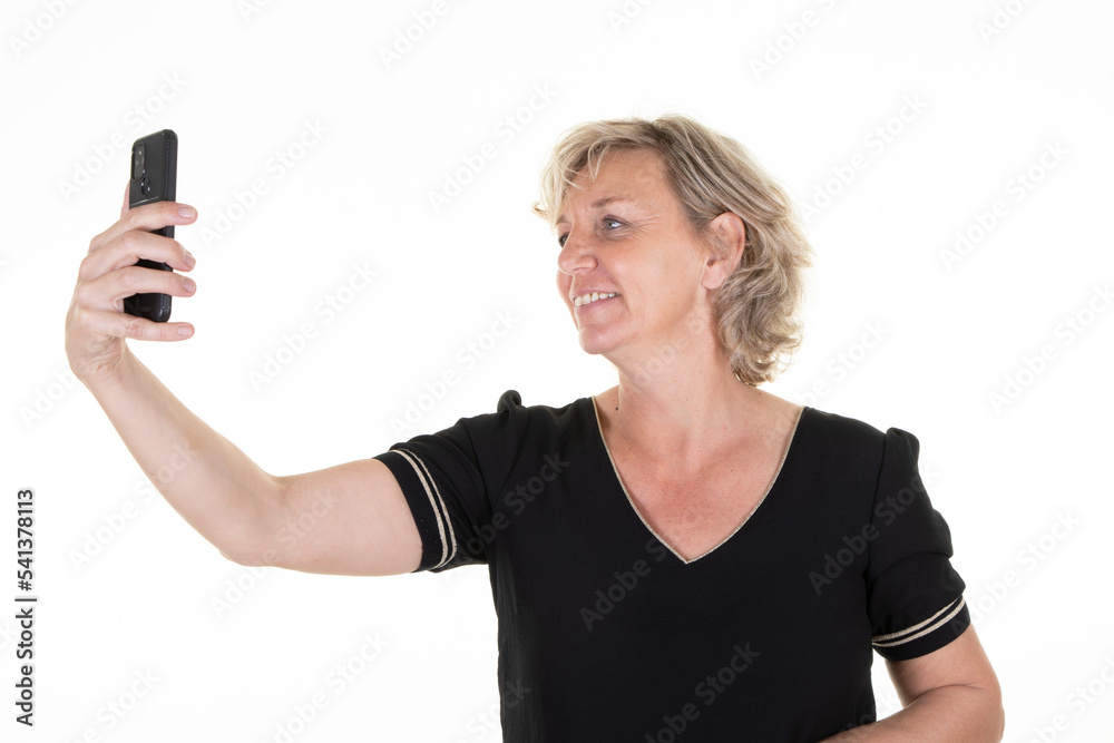 senior cheerful woman over isolated white background making phone selfie with camera smartphone in hand senior cheerful woman over isolated white background making phone selfie with camera smartphone in hand