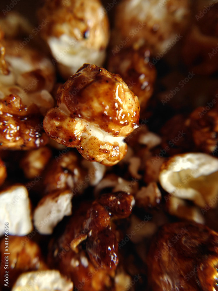 Sweet food a handful of brown popcorn with caramel close-up Sweet food a handful of brown popcorn with caramel close-up