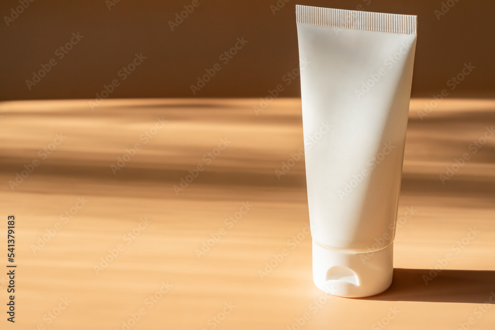 White cosmetic cream tube, balm jar mockup on beige background. Make up product blank container. Body and face care. White cosmetic cream tube, balm jar mockup on beige background. Make up product blank container. Body and face care.