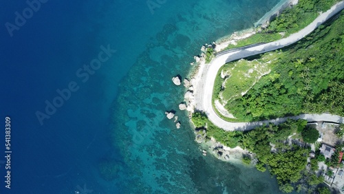 Aerial shot of the shore in Negros Oriental, Philippines, with the daylight reflection in the water photo