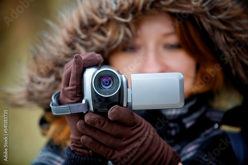 A video camera in the hands of a girl.