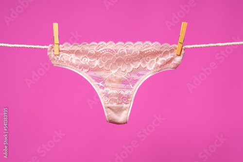 Canvastavla Female panties hanging on rope against pink studio background