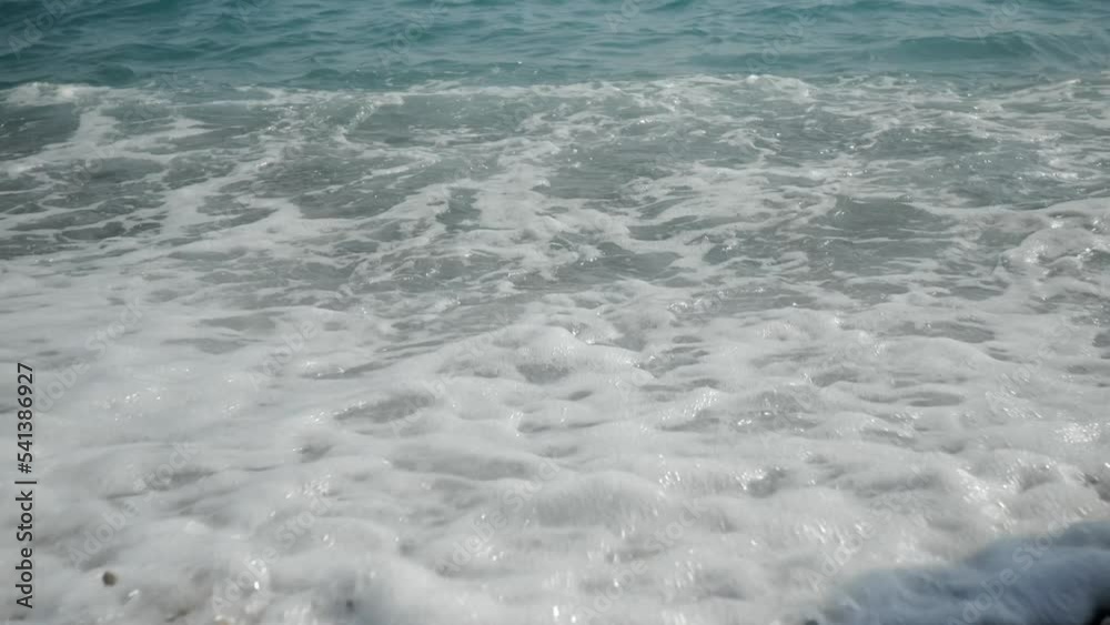 The legs of a little boy run in front of the camera against the backdrop of sea waves. High quality 4k footage The legs of a little boy run in front of the camera against the backdrop of sea waves. High quality 4k footage